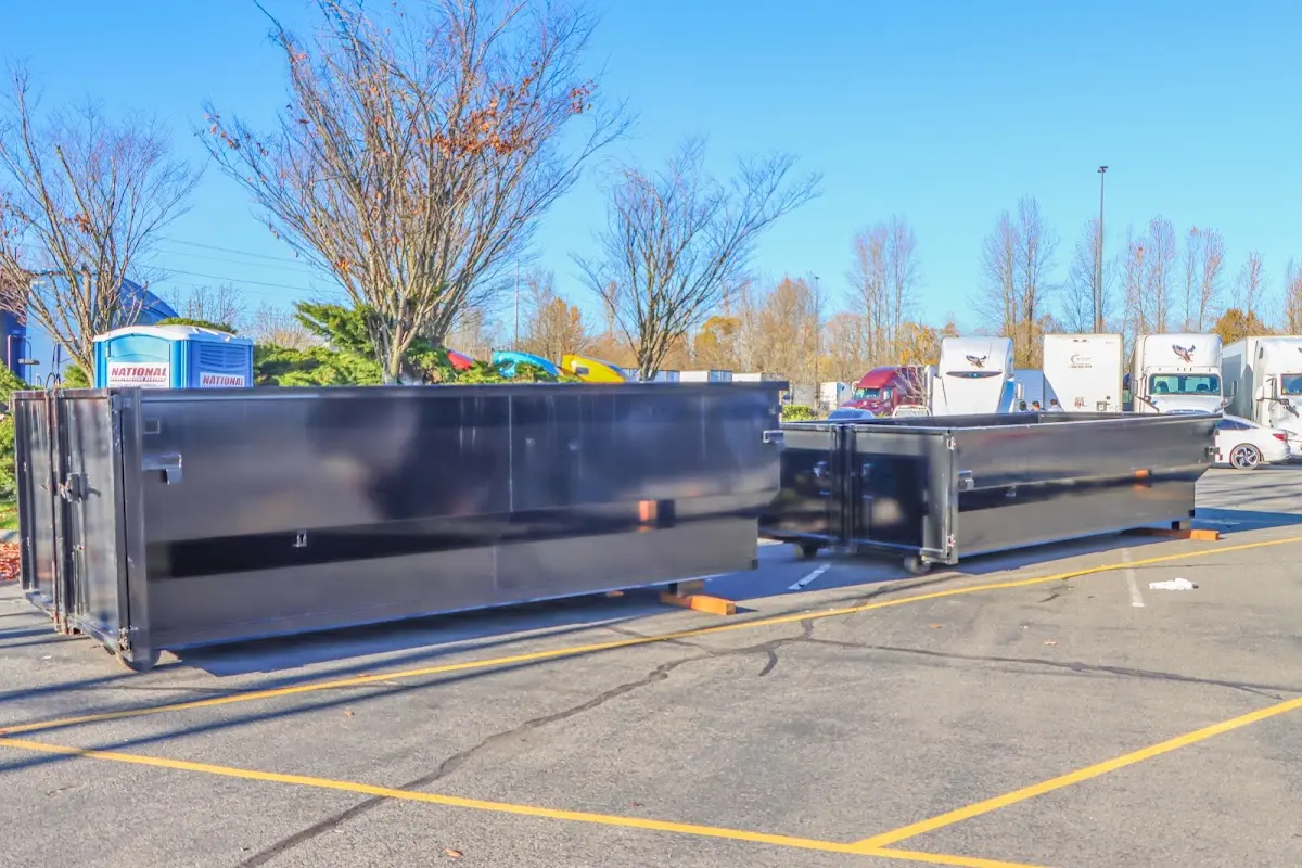 Professional dumpster rental service with roll-off container on residential driveway in West Perrine